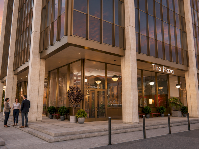 The Plaza hotel entrance with glass doors and offices, people walking outside, and a Mercedes parked at sunset.